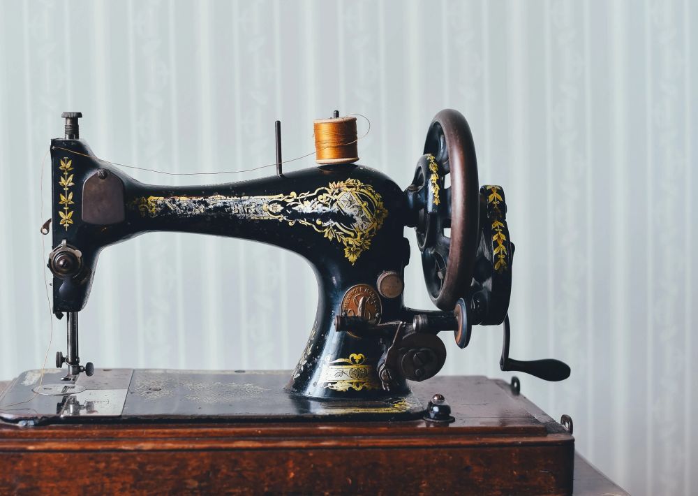 A student receiving one-on-one sewing guidance in a warm studio